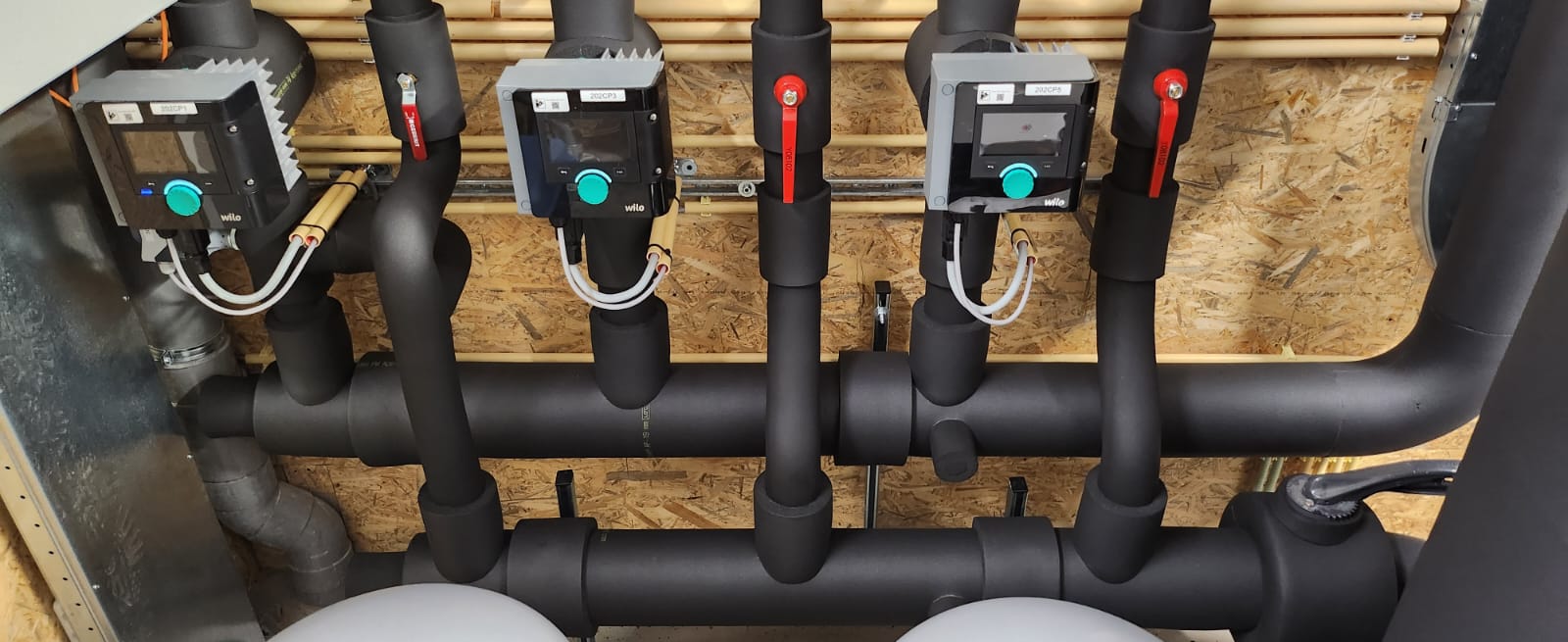 Warmtepomp verdeler met geïsoleerde leidingen in technische ruimte van woning
