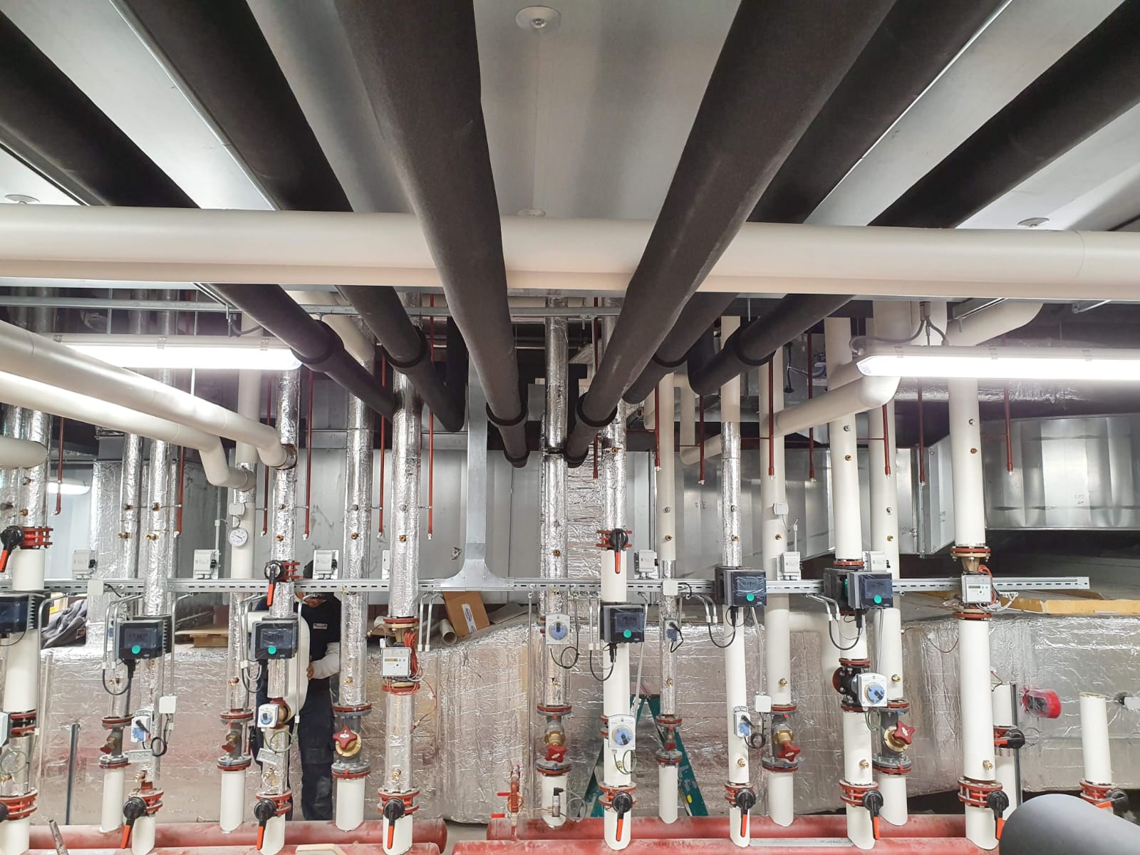 Parallel aangelegd leidingwerk van warmtepompinstallatie in technische ruimte