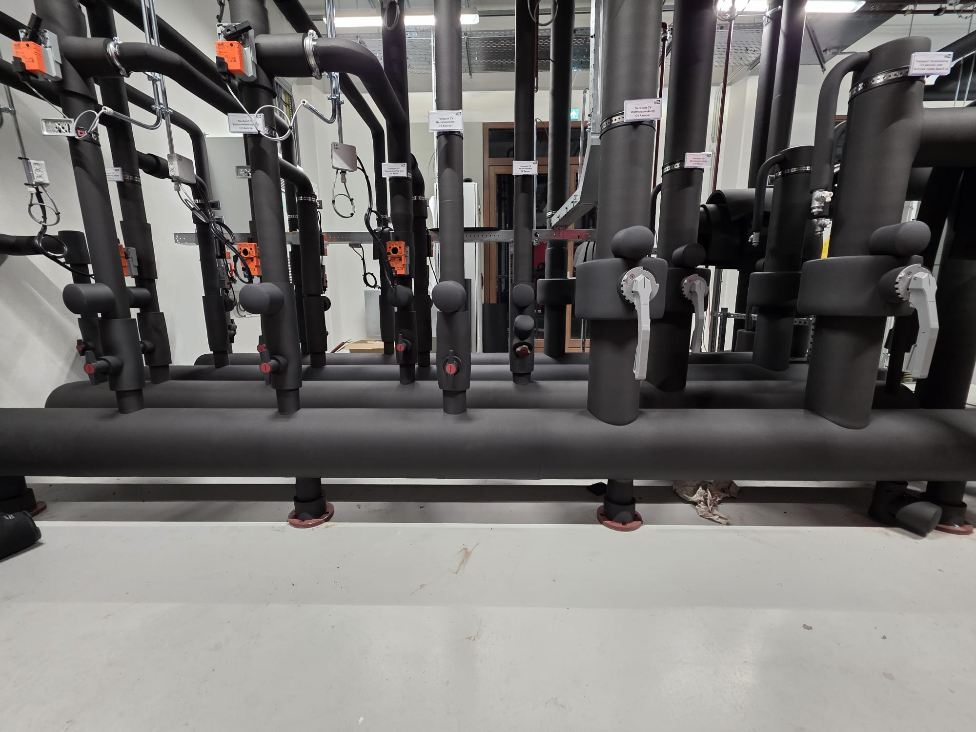 Warmtepomp leidingen en verdelers gemonteerd aan de vloer