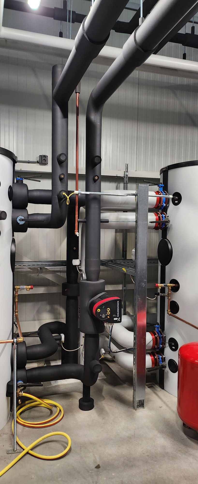 Verdeler en pompunit van warmtepomp met geïsoleerde buizen