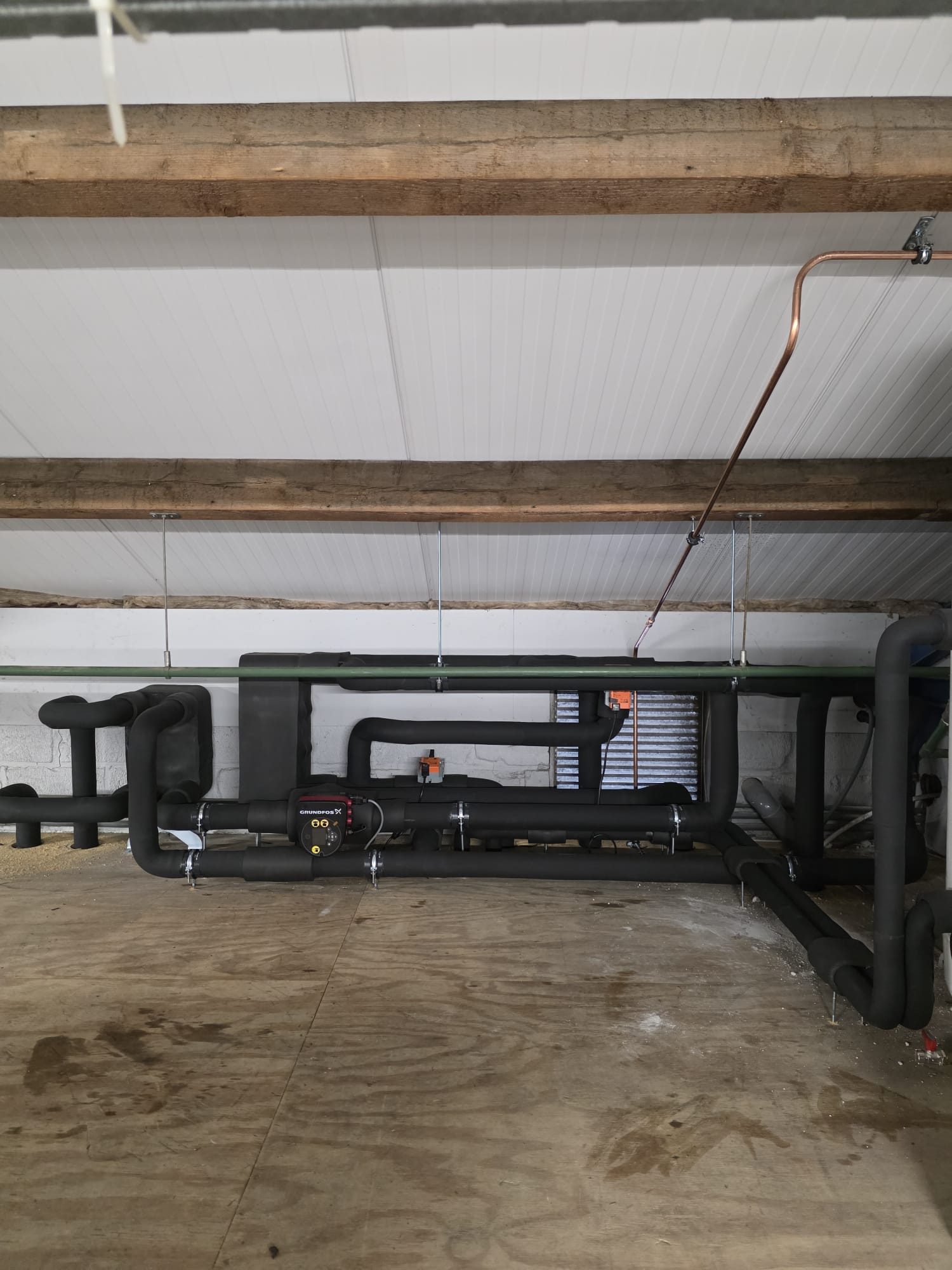 Technische ruimte met warmtepomp en horizontaal leidingwerk